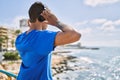 Young latin man on back view listening to music using headphones at the beach Royalty Free Stock Photo