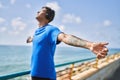 Young latin man breathing using headphones and smartphone at the beach Royalty Free Stock Photo