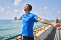Young latin man breathing using headphones and smartphone at the beach Royalty Free Stock Photo