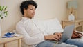 Young latin man business worker having video call sitting on bed at hotel room Royalty Free Stock Photo