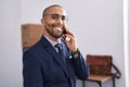 Young latin man business worker smiling confident talking on smartphone at office Royalty Free Stock Photo