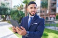 Young latin man business worker smiling confident using touchpad at park Royalty Free Stock Photo