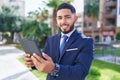 Young latin man business worker smiling confident using touchpad at park Royalty Free Stock Photo
