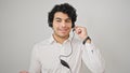 Young latin man business worker wearing headphones speaking over isolated white background Royalty Free Stock Photo