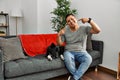 Young latin man and dog sitting on the sofa at home smiling cheerful showing and pointing with fingers teeth and mouth Royalty Free Stock Photo