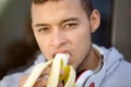 Young latin man eating banana fruit runner winter running sports training fitness