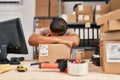 Young latin man ecommerce business worker leaning on package sleeping at office