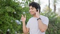 Young latin man listening to music and dancing at park Royalty Free Stock Photo