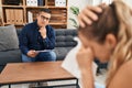 Young latin man psychologist speaking to patient at psychology clinic Royalty Free Stock Photo