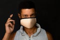 Young latin man removing his face mask and looking defiant Royalty Free Stock Photo