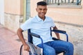 Young latin man smiling confident sitting on wheelchair at street Royalty Free Stock Photo