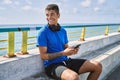 Young latin man smiling happy using headphones and smartphone at the beach Royalty Free Stock Photo