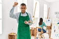 Young latin man standing at art studio annoyed and frustrated shouting with anger, yelling crazy with anger and hand raised Royalty Free Stock Photo