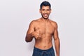 Young latin man standing shirtless doing happy thumbs up gesture with hand