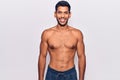 Young latin man standing shirtless with a happy and cool smile on face