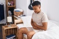 Young latin man suffering for stomach flu at bedroom Royalty Free Stock Photo