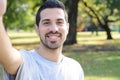 Young latin man taking a selfie in a park. Royalty Free Stock Photo