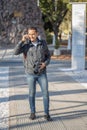 Young latin man talking on mobile phone with a photo camera around his neck Royalty Free Stock Photo
