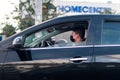 Young Latin man wearing a mask to avoid the spread of coronavirus while driving his black car on the streets of Bogota. Colombia.