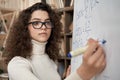 Young latin math school teacher wearing glasses writing on whiteboard Royalty Free Stock Photo