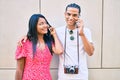 Young latin tourist couple talking on the smartphone at street of city Royalty Free Stock Photo