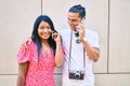 Young latin tourist couple talking on the smartphone at street of city Royalty Free Stock Photo