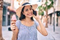 Young latin tourist girl on vacation talking on the smartphone eating ice cream at the city Royalty Free Stock Photo