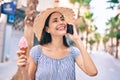 Young latin tourist girl on vacation talking on the smartphone eating ice cream at the city Royalty Free Stock Photo