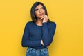Young latin transsexual transgender woman wearing casual clothes serious face thinking about question with hand on chin, Royalty Free Stock Photo