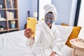 Young latin woman applying cream face mask make selfie by smartphone at bedroom