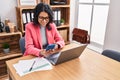 Young latin woman business worker using laptop and smartphone at office Royalty Free Stock Photo