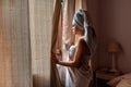 Young latin woman freshly bathed looking through the window