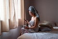 Young latin woman freshly bathed with mobile phone and coffee at home