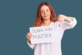 Young latin woman holding black lives matter banner with angry face, negative sign showing dislike with thumbs down, rejection