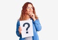 Young latin woman holding question mark serious face thinking about question with hand on chin, thoughtful about confusing idea Royalty Free Stock Photo