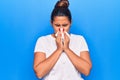 Young latin woman illness using paper handkerchief on nose