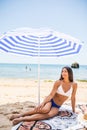 Young beauty latin woman lying on the sand under sun umbrella on the sea beach. Summer vocation Royalty Free Stock Photo