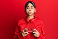 Young latin woman playing video game holding controller puffing cheeks with funny face Royalty Free Stock Photo