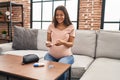 Young latin woman pregnant measuring glucose at home