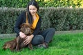 Young woman sitting on the grass next to her dog Royalty Free Stock Photo