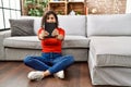 Young latin woman smiling confident holding bible at home