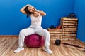 Young latin woman smiling confident stretching with fit ball at sport center Royalty Free Stock Photo