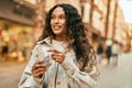 Young latin woman smiling happy counting colombia pesos banknotes at the city