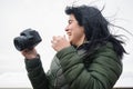 young latin woman smiling with her digital camera creating content for her social networks outdoors