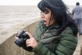 young latin woman tourist surprised looking at the photo she took with her camera on the pier Royalty Free Stock Photo