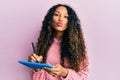 Young latin woman using touchpad writing on screen looking at the camera blowing a kiss being lovely and sexy Royalty Free Stock Photo