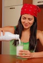 Woman pouring milk glass home. Royalty Free Stock Photo