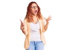 Young latin woman wearing business clothes crazy and mad shouting and yelling with aggressive expression and arms raised Royalty Free Stock Photo