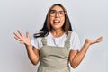Young latin woman wearing casual clothes and glasses crazy and mad shouting and yelling with aggressive expression and arms raised Royalty Free Stock Photo