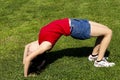 Young Hispanic Woman Bending Over Backwards On Green Grass Royalty Free Stock Photo